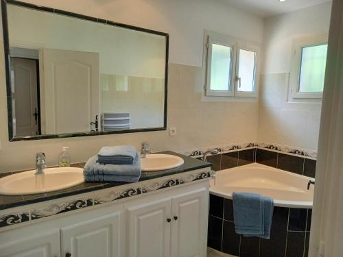 une salle de bain avec deux lavabos et un grand miroir dans l'établissement Villa au calme le brusc, à Six-Fours-les-Plages