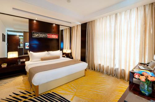 a hotel room with a bed and a desk at Brilliant Hotel - Afternoon Tea Inclusive in Da Nang