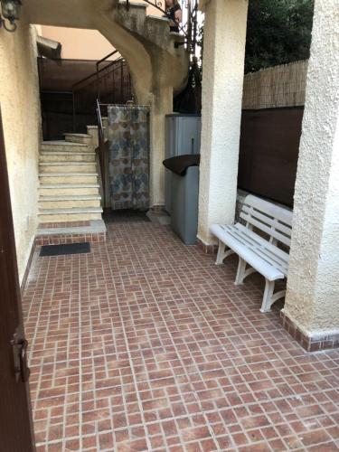 a brick walkway with a bench and stairs at Appartamenti Alessandro in Agnone Bagni
