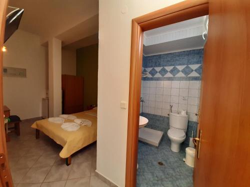 a bedroom with a bed and a bathroom with a toilet at Paraga Rooms Pefkari in Pefkari