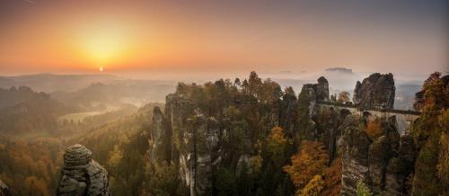a castle on a mountain with the sunset in the background at Haus am Wald in Bad Schandau