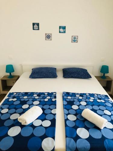 a bed with blue and white polka dot sheets and pillows at Lavanda Centar Vir in Vir