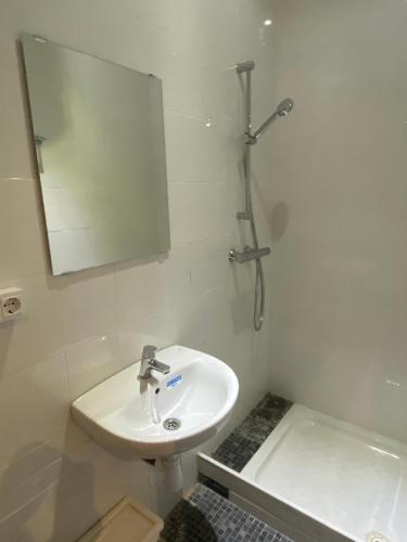 a white bathroom with a sink and a mirror at Hostal Granvia 628 in Barcelona