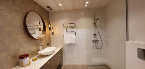 a bathroom with a sink and a shower with a mirror at Aia apartement in Kuressaare