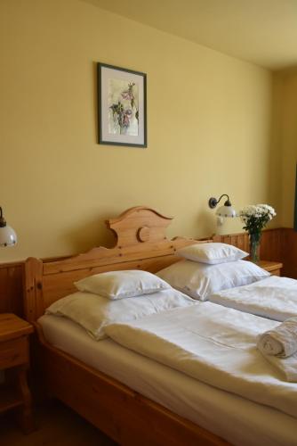 a bedroom with two beds with white sheets at Bozi Rozi Panzió in Fertőboz