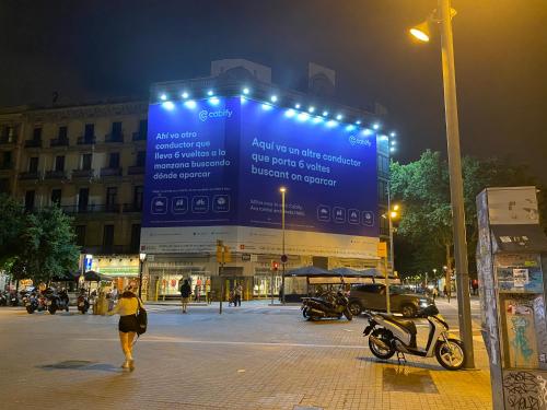 a woman walking down a city street at night at Hostal Granvia 628 in Barcelona