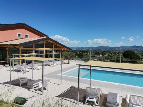 basen z krzesłami i dom w obiekcie Agriturismo Incanto della Natura w mieście Cannara