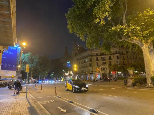 a car driving down a city street at night at Hostal Granvia 628 in Barcelona
