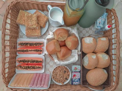 ein Korb mit verschiedenen Brotsorten und Lebensmitteln in der Unterkunft Pousada Cabanas Porto Belo in Bombinhas