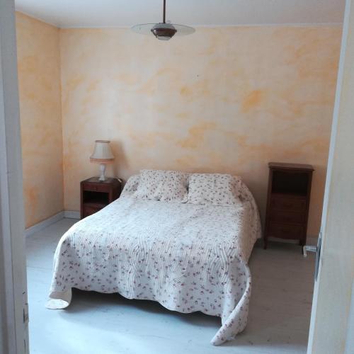 une chambre avec un lit avec une couette blanche dans l'établissement les mésanges, à Chaffaut-Lagremuse