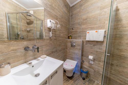 a bathroom with a sink and a shower and a toilet at Guest House S-Lux in Petrovac na Moru