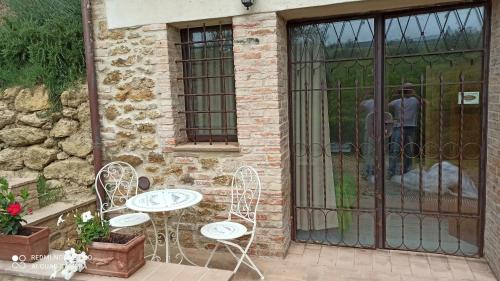 a couple of chairs and a table in front of a door at Rocca degli Olivi in San Gimignano