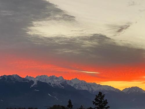 a sunset over the mountains with a red sky at Chez Chantal in Siviez