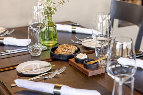 a wooden table with plates and glasses and a tray of food at Hotel Kettenbrücke in Aarau