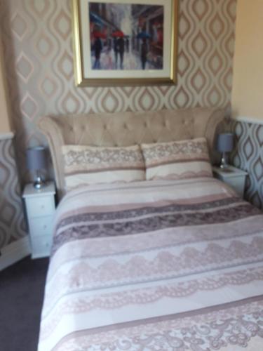 a bedroom with a large bed with a picture on the wall at Delamere Hotel in Blackpool