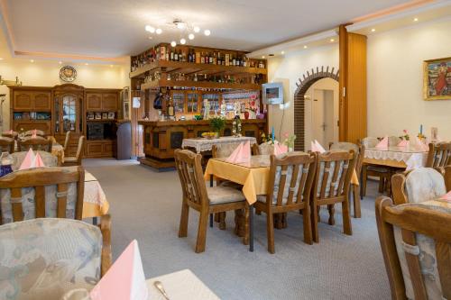 uma sala de jantar com mesas e cadeiras num restaurante em Hotel Restaurant Rehberg em Sankt Andreasberg