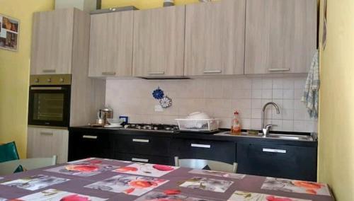 a kitchen with wooden cabinets and a table with a counter top at Camera matrimoniale a due passi dal mare in Cervia