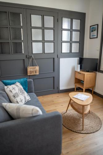 un salon avec un canapé bleu et une table dans l'établissement CRYSTAL, à Saint-Malo