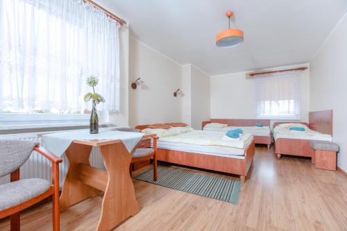 a room with three beds and a table at Malinka in Rewal