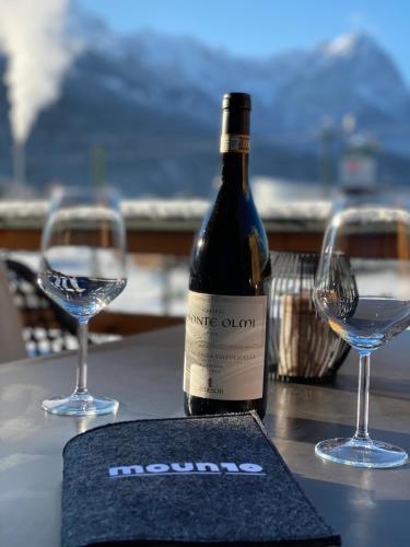 a bottle of wine and two glasses on a table at moun10 urlaubswohnen in Garmisch-Partenkirchen