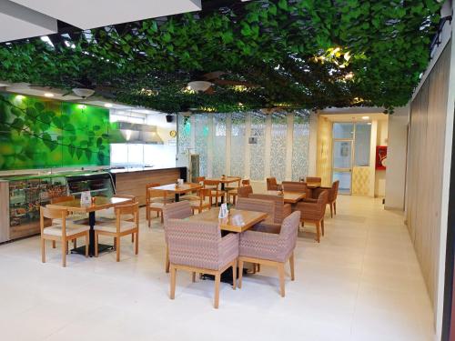 a restaurant with wooden tables and chairs and green ceilings at Hotel Rosales Boutique in Neiva