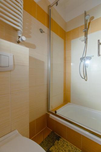a bathroom with a shower and a toilet and a tub at Malinka in Rewal