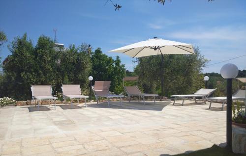 a group of chairs and an umbrella on a patio at Trullo Le Tre Sorelle in Cisternino