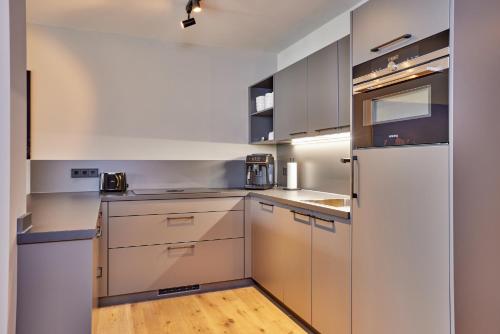 a kitchen with white cabinets and a refrigerator at moun10 urlaubswohnen in Garmisch-Partenkirchen