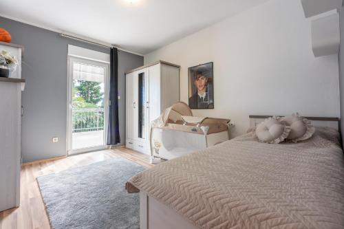 a white bedroom with a bed and a mirror at Family Heritage in Crikvenica