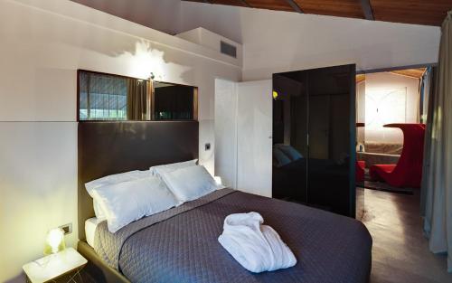 - une chambre avec un lit et des serviettes blanches dans l'établissement Il Tesoro Living Resort, à Rodigo