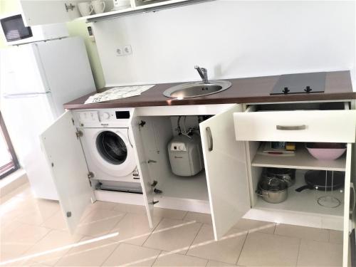 a kitchen with a sink and a washing machine at Private apartments Stamopolu lux in Primorsko