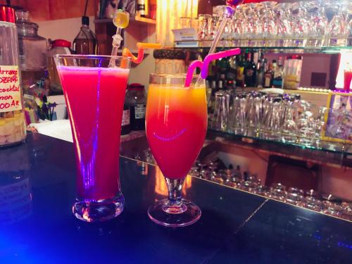 two cocktails in glasses sitting on a bar at Petite Flower Guest House in Talata-maty