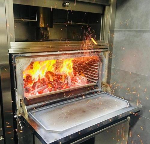 a grill with a fire inside of it at Hotel Dos Rios Central in Aínsa