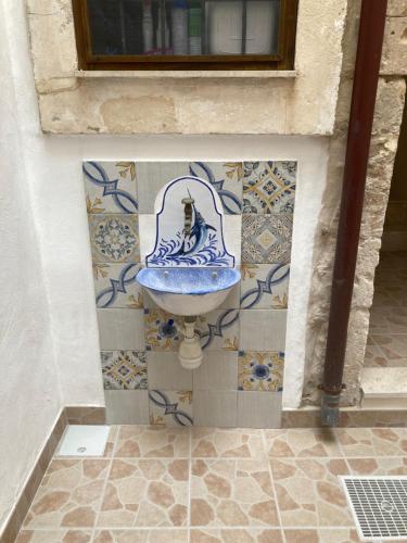 a bathroom with a blue sink on a wall at The Ronco Apartment in Siracusa