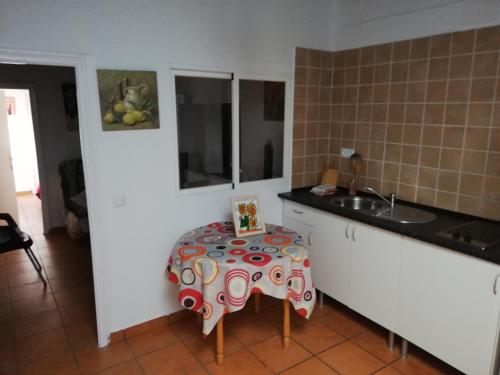 - une cuisine avec une table et un évier dans l'établissement Casas Manolo, à Vejer de la Frontera