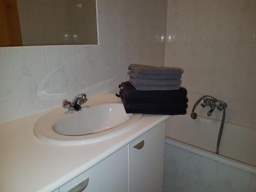 ein Badezimmer mit einem Waschbecken und Handtüchern auf der Theke in der Unterkunft Zonnig Appartement Golf van Durbuy in Durbuy