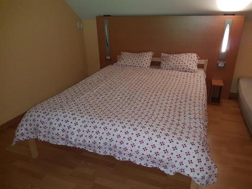 ein Schlafzimmer mit einem Bett mit einer rot-weißen Tagesdecke in der Unterkunft Zonnig Appartement Golf van Durbuy in Durbuy