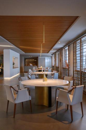 a dining room with tables and white chairs at Hotel Royal Paestum in Paestum