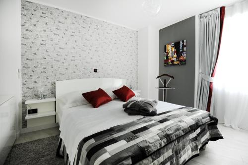 1 dormitorio con 1 cama blanca grande con almohadas rojas en Feel Good Penthouse With Jacuzzi, en Zadar