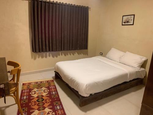 1 dormitorio con cama, ventana y alfombra en Nonna Aisha B&B en Wadi Musa