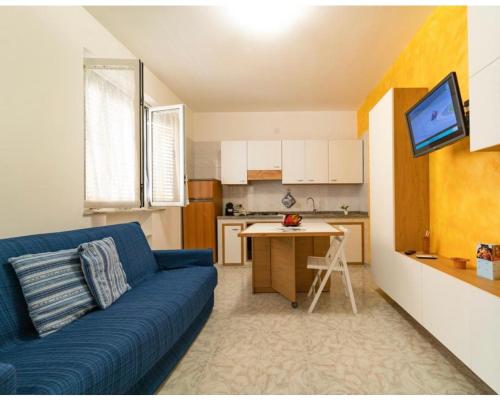 un soggiorno con divano blu e una cucina di Via San Giacomo piano rialzato a Ustica