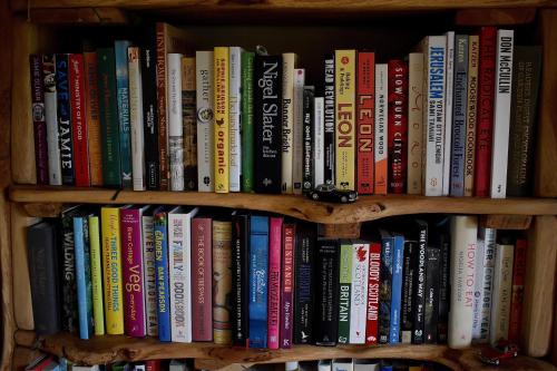 a book shelf filled with lots of books at Ardmore House B&B in Lochinver