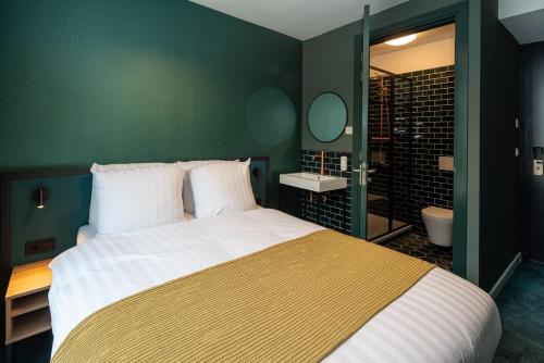 ロッテルダムにあるFD Hotelsの緑の壁のベッドルーム1室(大型ベッド1台付)
