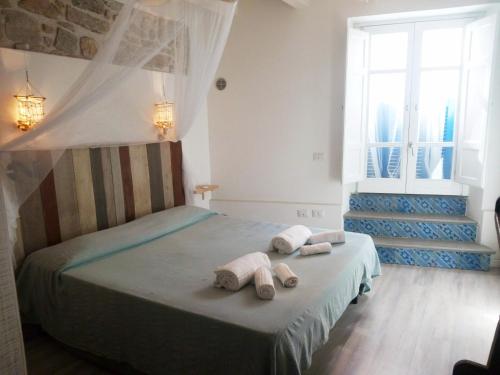 una camera da letto con un letto e asciugamani di B&B Terra - Stanza Natura a Carloforte