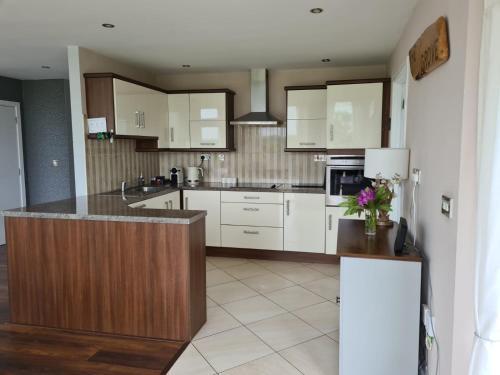 a kitchen with white cabinets and a counter top at The Grove in Belturbet