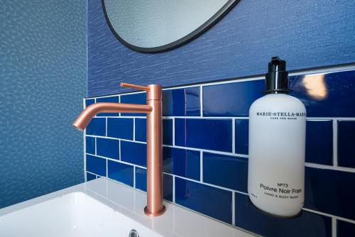 鹿特丹的住宿－FD Hotels，浴室水槽,在镜子旁装有一瓶水