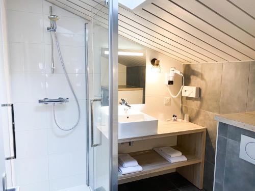 a bathroom with a shower and a sink and a mirror at Hôtel Restaurant Le Grand Large - Face à la plage - Ile de Ré in Rivedoux-Plage