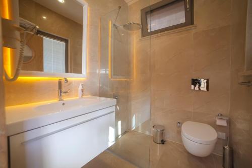 uma casa de banho com um lavatório, um WC e um espelho. em Mekvin Hotels Deniz Feneri Lighthouse em Kas