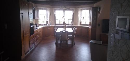Wynajem Pokoi Osada في فواديسوافوفو: مطبخ مع طاولة وكراسي ونوافذ