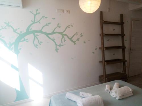 una camera da letto con un murale sull'albero di B&B Terra - Stanza Natura a Carloforte